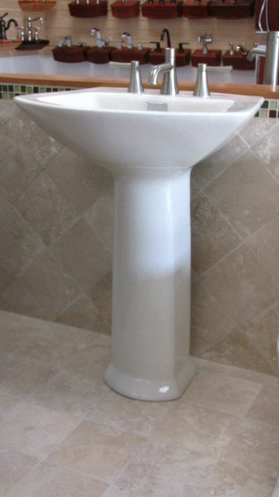a pedestal sink with faucet
